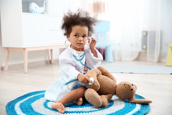 Child using a stethoscope on a teddy bear